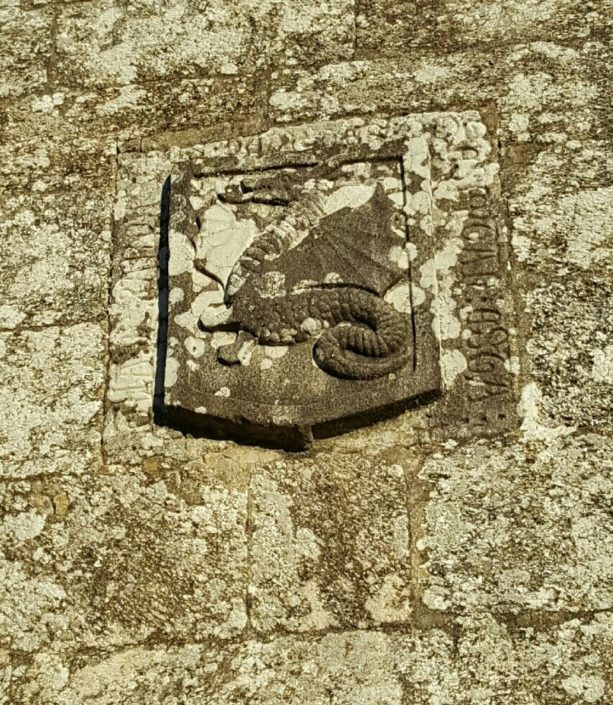 Escudo con dragón alado en la fachada de la iglesia de Santa María de Marrozos
